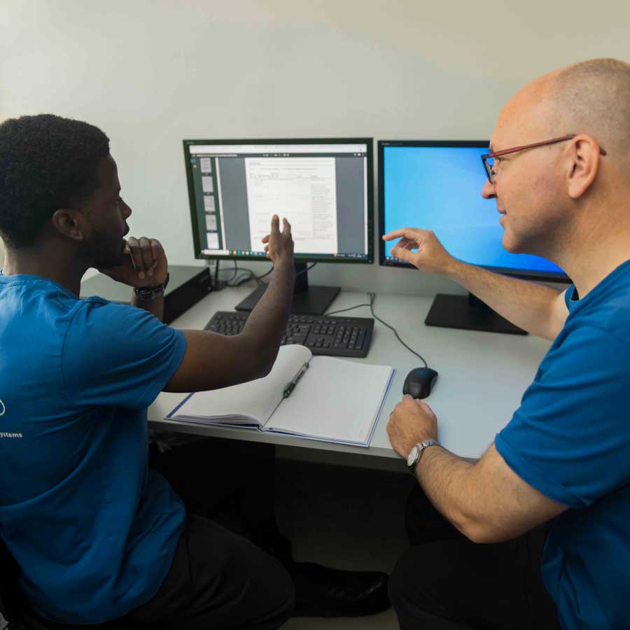 The mentor discusses with the trainee at the screen