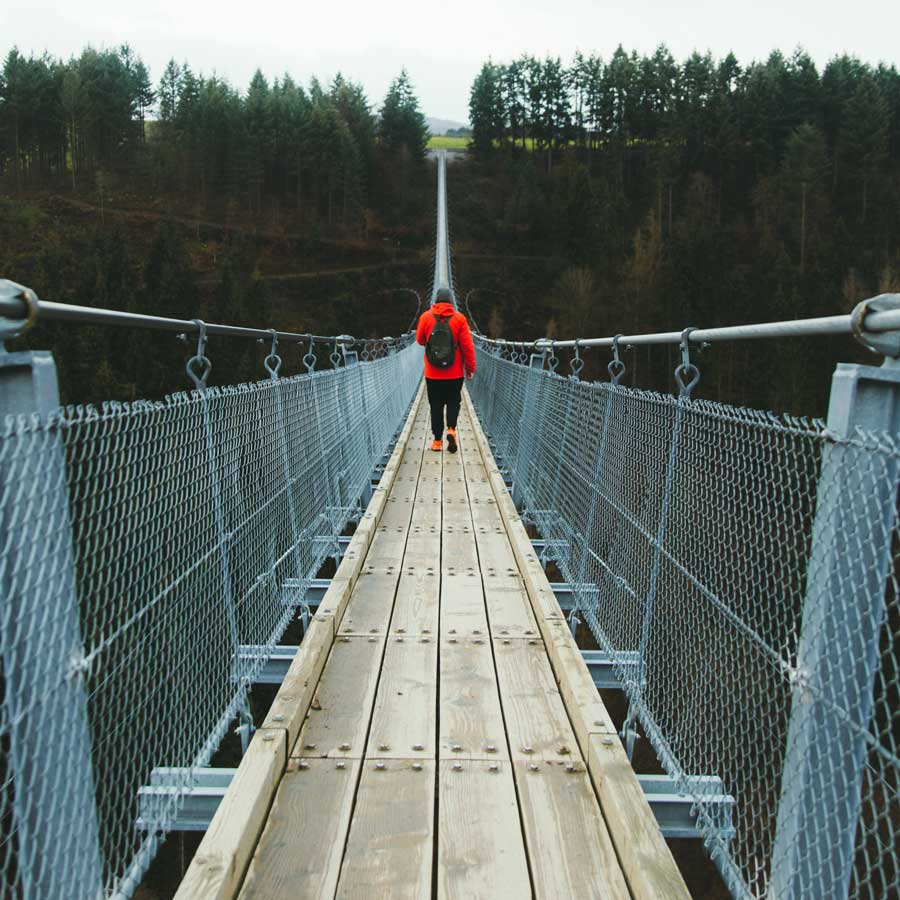 Man walking on a foot suspension bridge